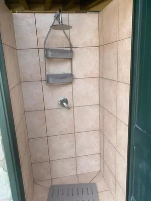 a bathroom with a shower with a toilet and a shelf at Villa Maria in Campofelice di Roccella