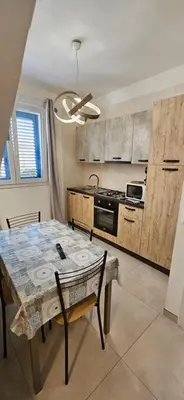 a kitchen with a table and a dining room at Jecko Apartment in San Vito lo Capo