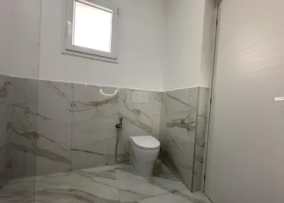 a bathroom with a toilet and a window at BreMi Rooms B&B in San Vito lo Capo
