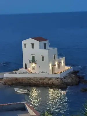 a white house on a island in the water at Casetta Bianca Luxury in Santa Flavia