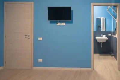 a bathroom with a door with a tv on the wall at Bivio 281 suite&rooms in Carini
