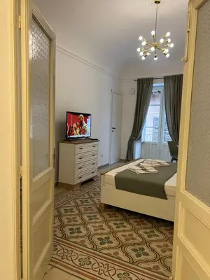 a bedroom with a bed and a television in it at Appartamenti Tiffany & Timi in Carini