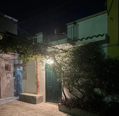 a building with a green door and a balcony at Antica Dimora Vaglica in Palermo