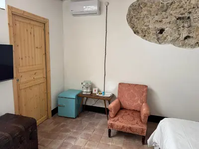 a bedroom with a bed and a chair and a table at Antica Dimora Vaglica in Palermo