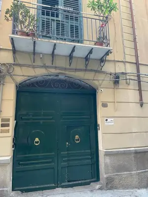 a green door on a building with a balcony at Al Duomo apartment in Palermo in Palermo