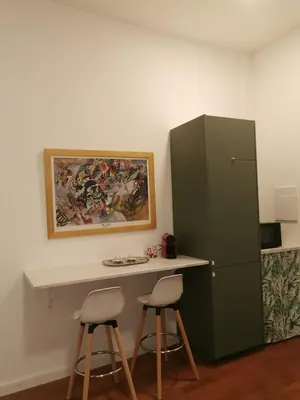 a desk with two stools and a green cabinet at Le case di Giù in Palermo