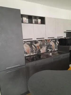 a kitchen with white cabinets and a stainless steel sink at Ottolune Accomodations in Campofelice di Roccella