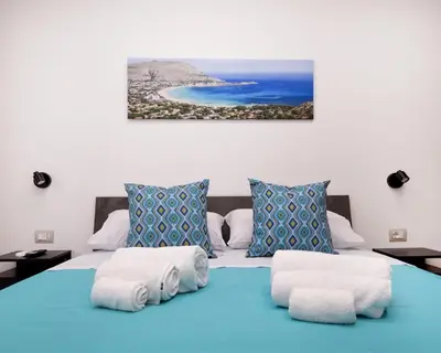 a bedroom with a blue bed with a view of the ocean at Matrice Rooms in Palermo