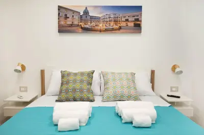 a bedroom with a blue bed with white sheets and pillows at Matrice Rooms in Palermo