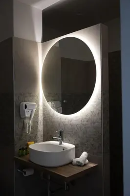 a bathroom with a sink and a round mirror at Matrice Rooms in Palermo