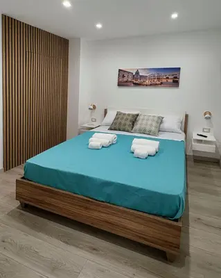 a bedroom with a large bed with towels on it at Matrice Rooms in Palermo