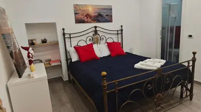 a bedroom with a black bed with red pillows at Casuzza del genio in Palermo