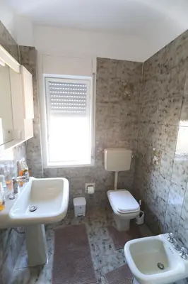 a bathroom with a sink and a toilet and a window at Twins House Vacation Home in Carini