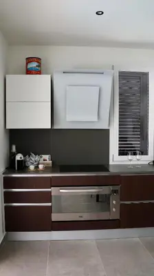 a kitchen with brown and white cabinets and a window at Villa Zagara modern villa with pool in Lascari