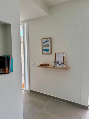 a white wall with a shelf in a room at Villa Zagara modern villa with pool in Lascari