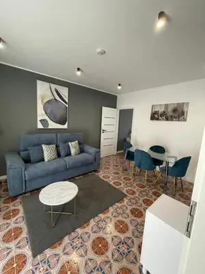 a living room with a blue couch and a table at Vento di Sicilia in Carini