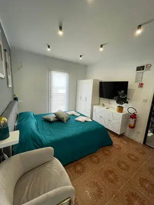a bedroom with a blue bed and a tv at Vento di Sicilia in Carini