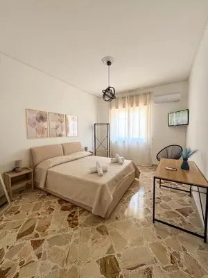 a bedroom with a large bed and a table at Casa Nonna Pina in Palermo