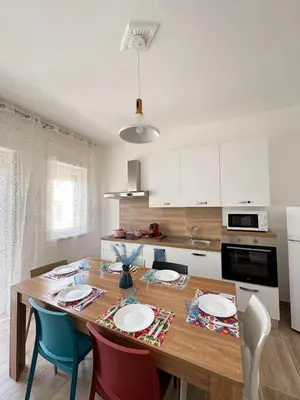 a kitchen with a wooden table and some chairs at Casa Nonna Pina in Palermo