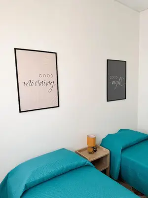 two beds in a room with two blue sheets at Casa Nonna Pina in Palermo
