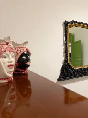 a mask and a mirror on a table at santa Rosalia home in Palermo