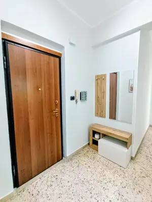 a bathroom with a wooden door and a mirror at Casa Hyccarina in Carini