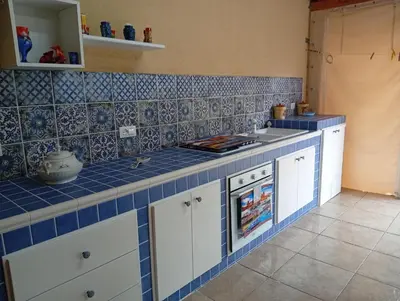 a kitchen with blue tiles on the wall and a counter at lia&gio' in Campofelice di Roccella
