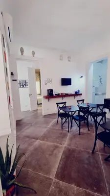 a dining room with tables and chairs and a television at Le Suite Vintage del Corso in Palermo
