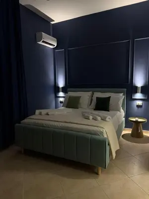 a bedroom with a large bed with a blue wall at Magione House Rooms in Palermo
