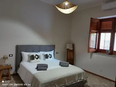 a bedroom with a bed and a chandelier at Il Gelsomino in Bagheria