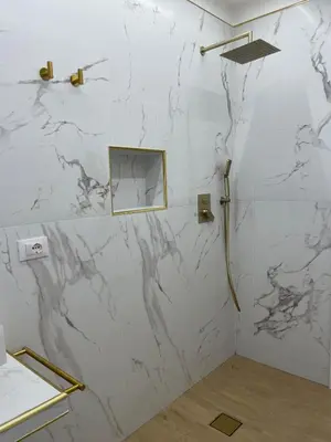 a bathroom with white marble walls and a shower at Maison Ferba in Palermo