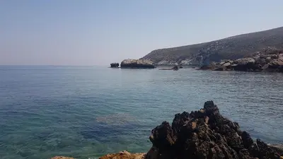 a large body of water with rocks and the ocean at Appartamento vista mare in Castellammare del Golfo