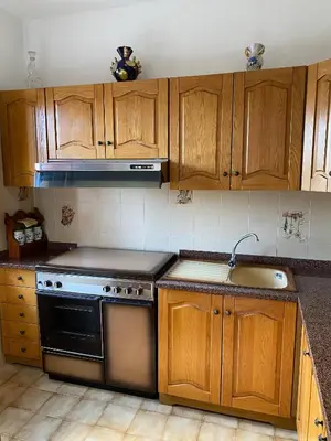 a kitchen with wooden cabinets and a stove and a sink at Charming Historic Villa in Vita, Sicily - Your Home Away from Home in Vita
