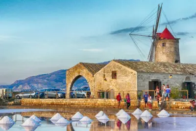 a group of people standing around a windmill at Charming Historic Villa in Vita, Sicily - Your Home Away from Home in Vita