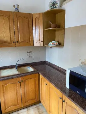 a kitchen with wooden cabinets and a sink at Charming Historic Villa in Vita, Sicily - Your Home Away from Home in Vita