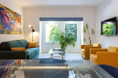 a living room with a couch and a table at Finestre sul Massimo - Centro Storico Palermo in Palermo
