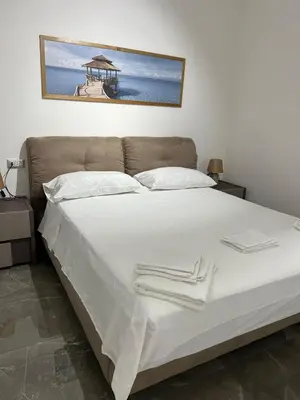 a bed with white sheets and white towels on it at NR Apartment in Palermo