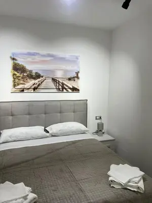 a bedroom with a bed with a painting on the wall at NR Apartment in Palermo