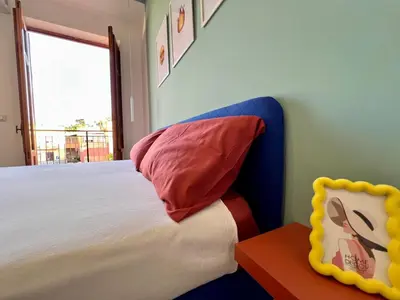 a bedroom with a bed with a pillow and a window at GiraSole in Palermo