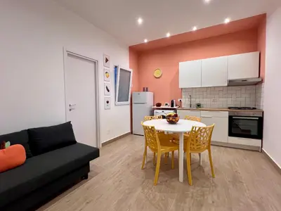 a kitchen and a living room with a table and chairs at GiraSole in Palermo