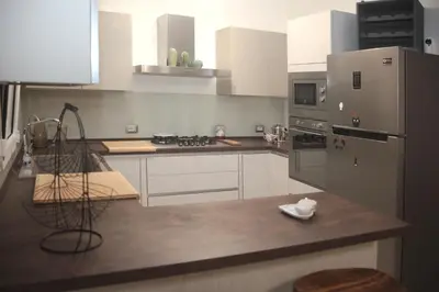 a kitchen with white cabinets and stainless steel appliances at Montalcini 3 in Capaci