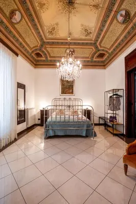 a bedroom with a bed and a ceiling with a chandelier at Artista Apartment in Alcamo