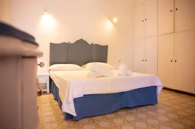 a bedroom with a large bed with white sheets at Solemar Sicilia - Villa Giovitto in Bagheria