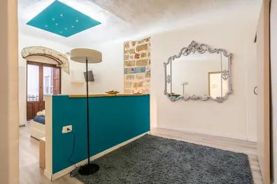 a hallway with a white table and a brick wall at Historic soul apartment in Palermo