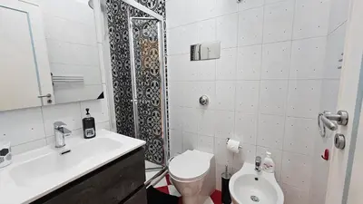 a bathroom with a toilet and a sink and a shower at 