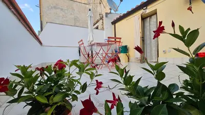 a patio with red flowers and a table and chairs at 