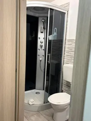a bathroom with a toilet and a glass shower at Cortili Himeresi in Termini Imerese