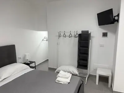 a bedroom with a bed and a tv in it at Cortili Himeresi in Termini Imerese