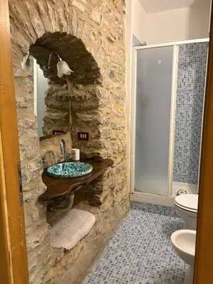 a stone bathroom with a sink and a toilet at Cortili Himeresi in Termini Imerese