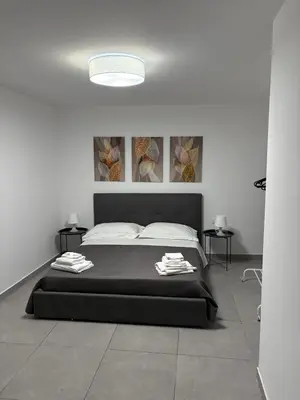 a bedroom with a large bed and two tables at Cortili Himeresi in Termini Imerese